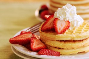 Waffles topped with delicious Florida strawberries and whipped cream