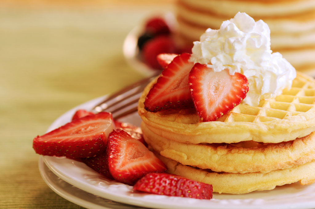 Waffles topped with delicious Florida strawberries and whipped cream